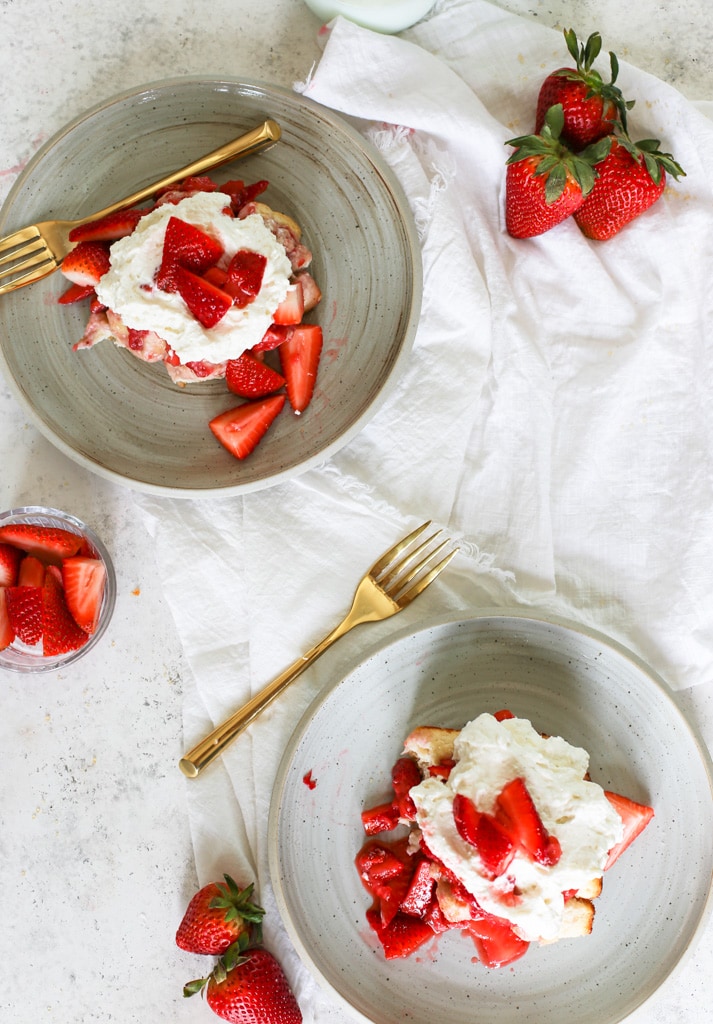 This image shows an overhead look at two pieces of served strawberry shortcake casserole on plates.