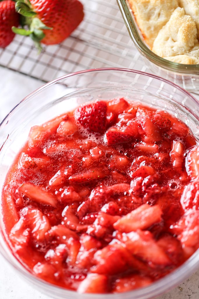 This image shows an overhead look at cut-up strawberries in a strawberry sauce.